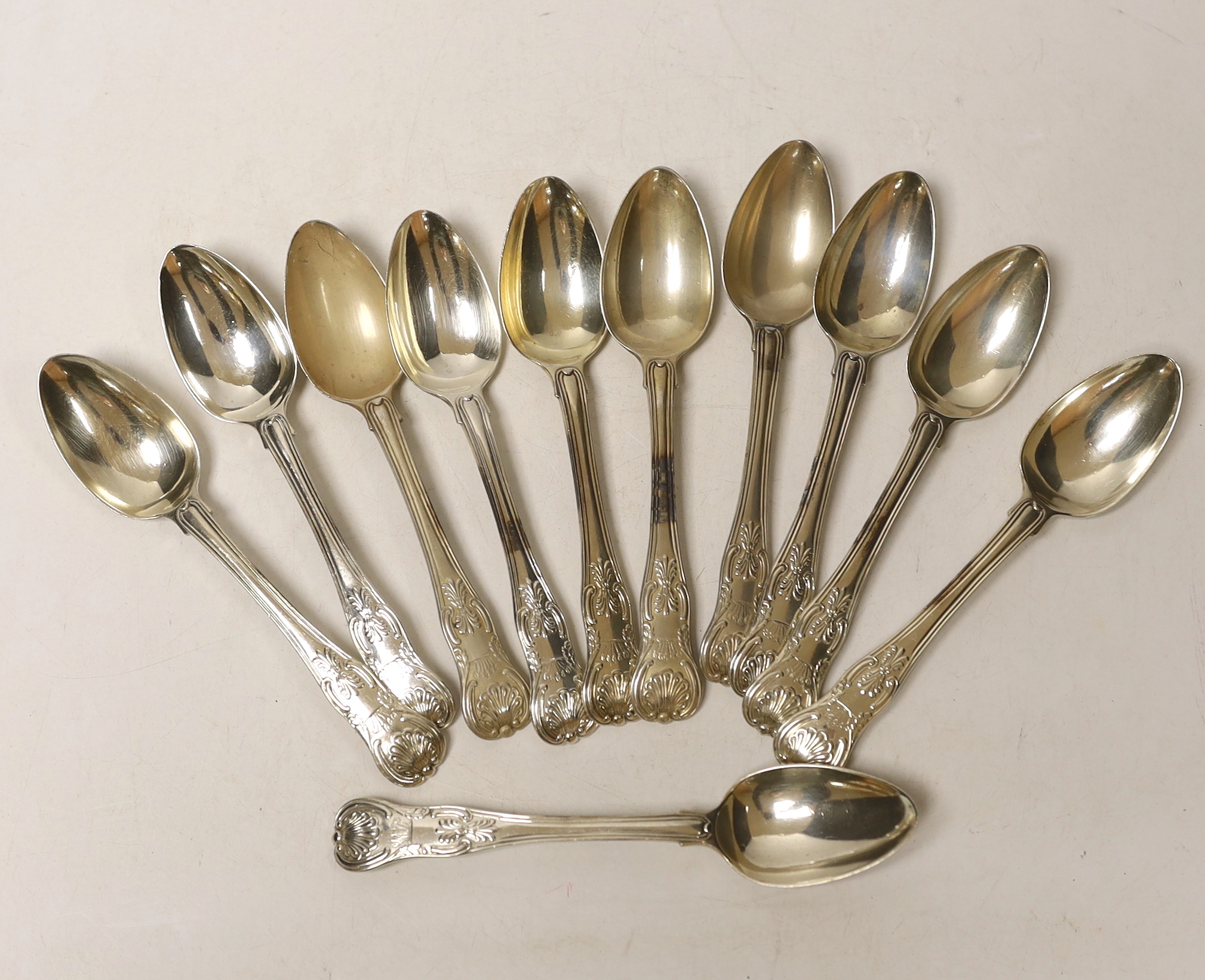 Eleven George IV silver Kings honeysuckle pattern teaspoons, William Chawner II, London, 1820, 12.8oz, with engraved crest.